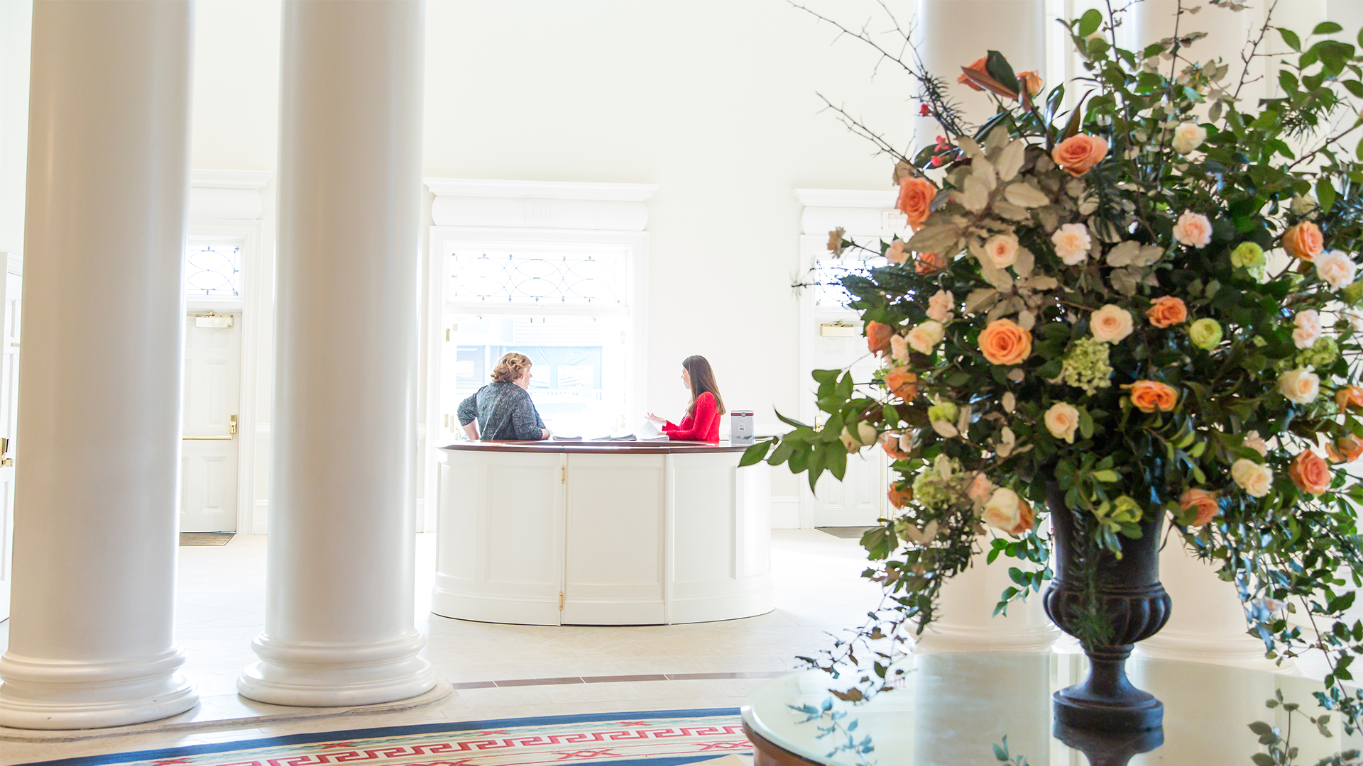 A beautiful flower arrangement in the Narthex with welcome volunteers at Peachtree Road United Methodist Church in Atlanta.